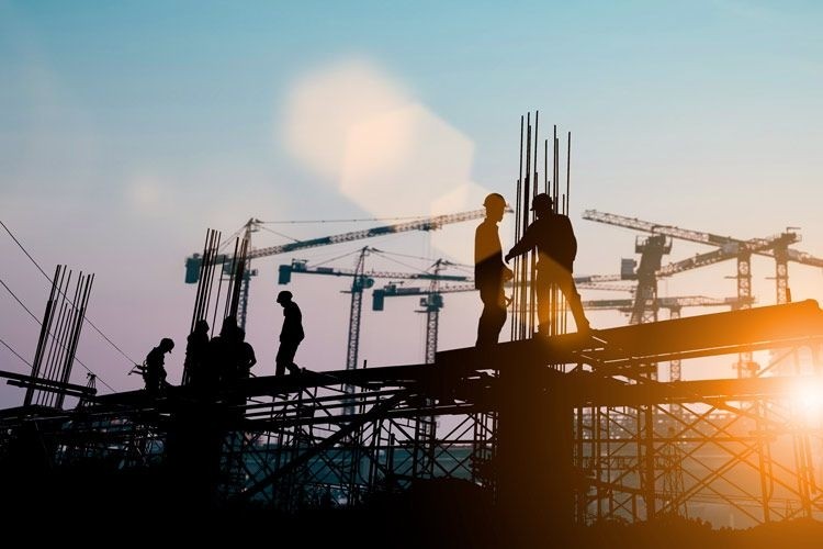 engineer-construction-team-981344368_compressed Engineer and construction team collaborating at construction job site.
