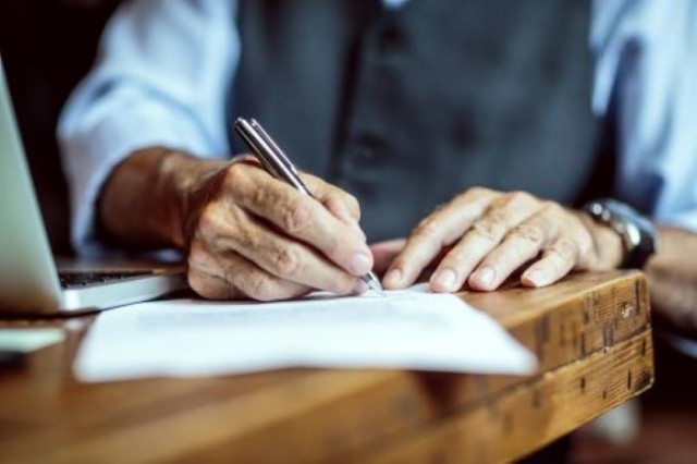 man signing document