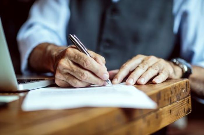 man signing document