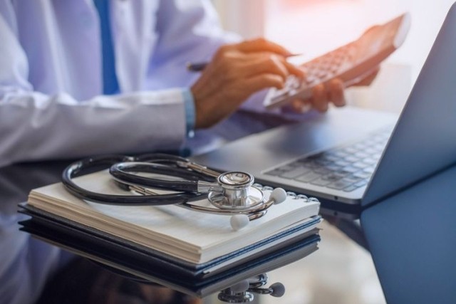 Health practitioner calculates medical coverage and affordability percentage adjustment..