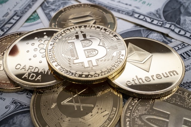 A selection of different cryptocurrency coins piled together over US dollar